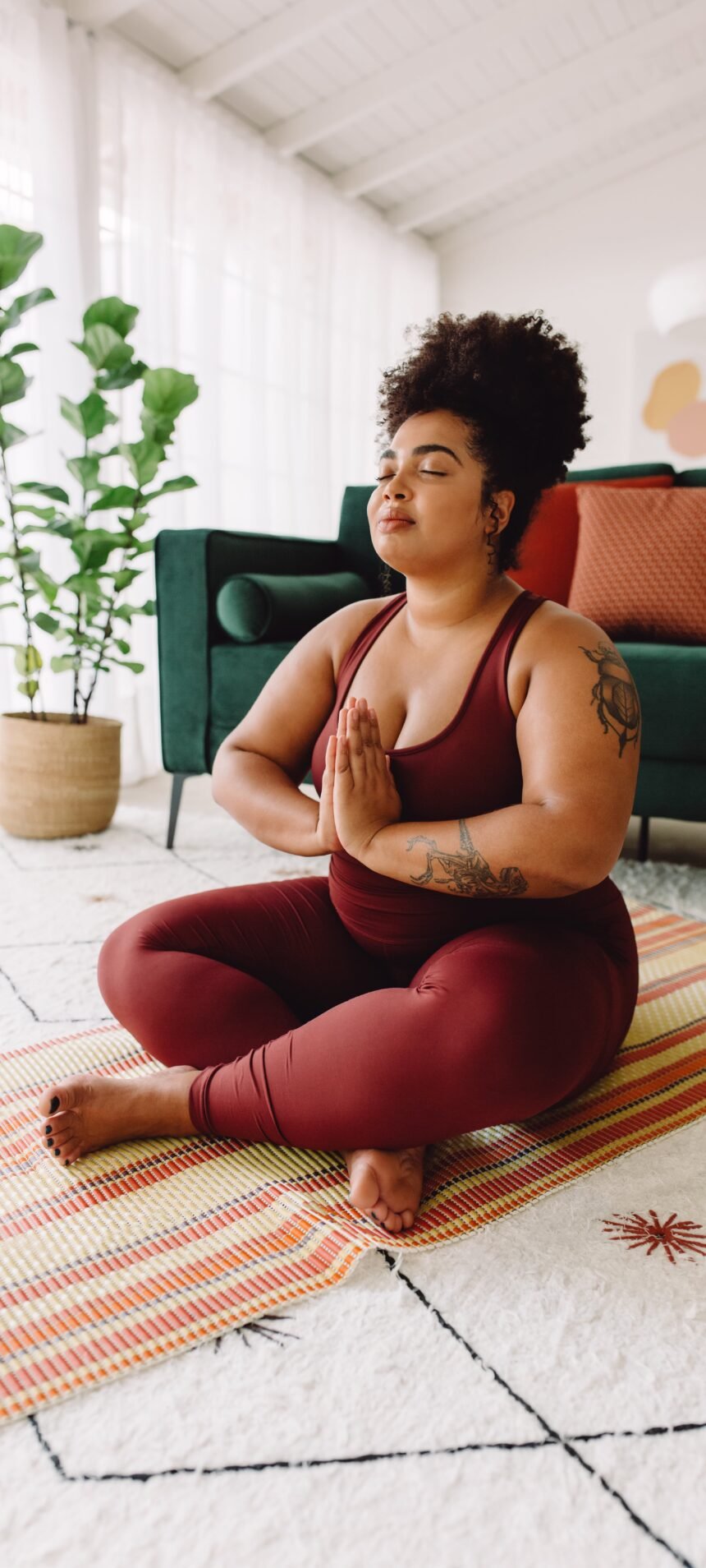 MEDITACAO NAO USAR APOS ESSA DATA 27-06-2024 EM CASO DE DUVIDA CONSULTE A FOTOGRAFIA Healthy woman with eyes closed practicing yoga in living room. Female in sports clothing sitting in lotus position.photo (JLco) Julia Amaral / adobe.stock