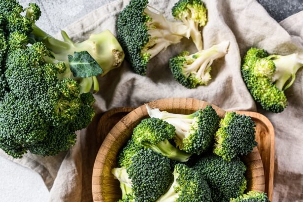 Raw broccoli in a wooden bowl. Gray background. Top view.